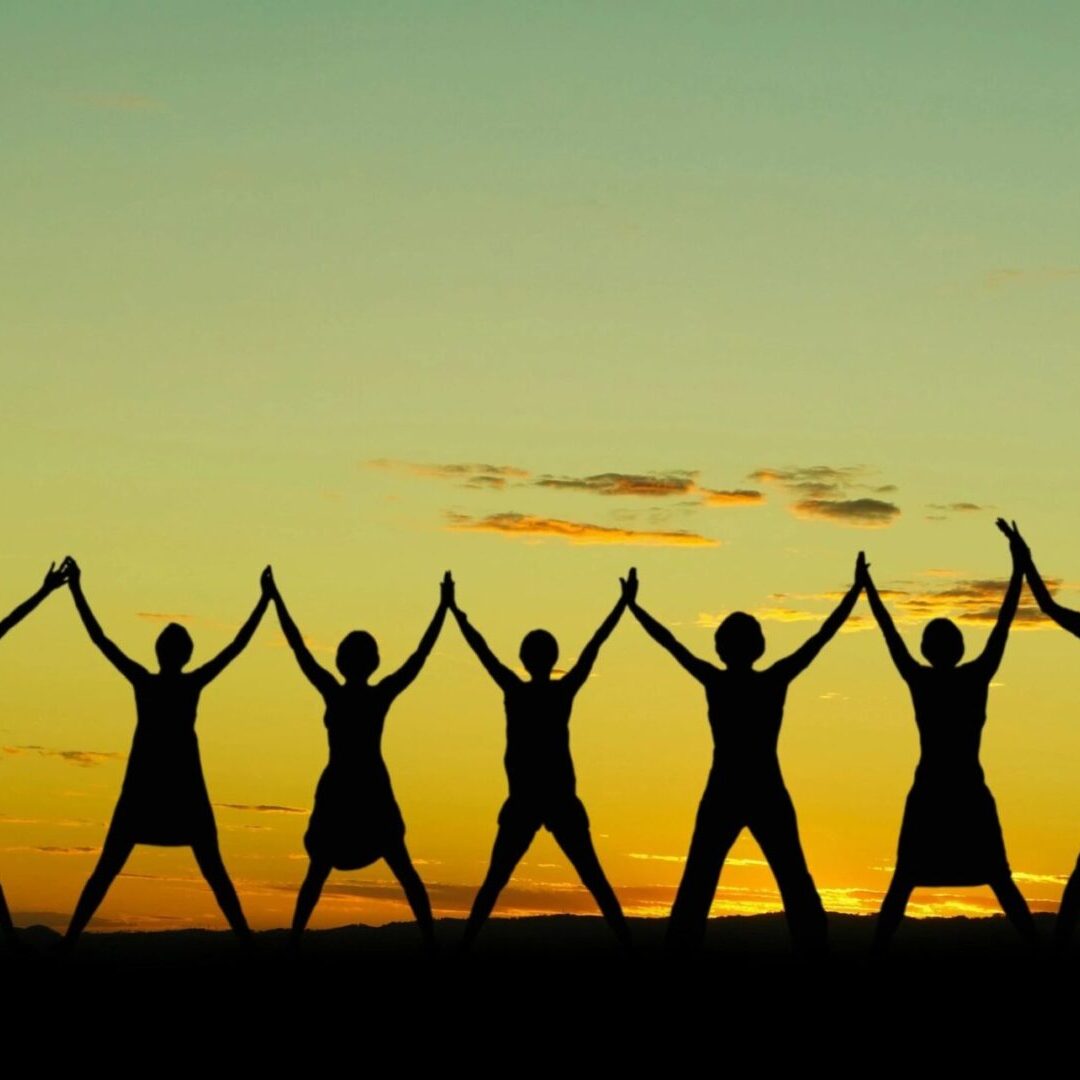 A group of people holding hands in the air.